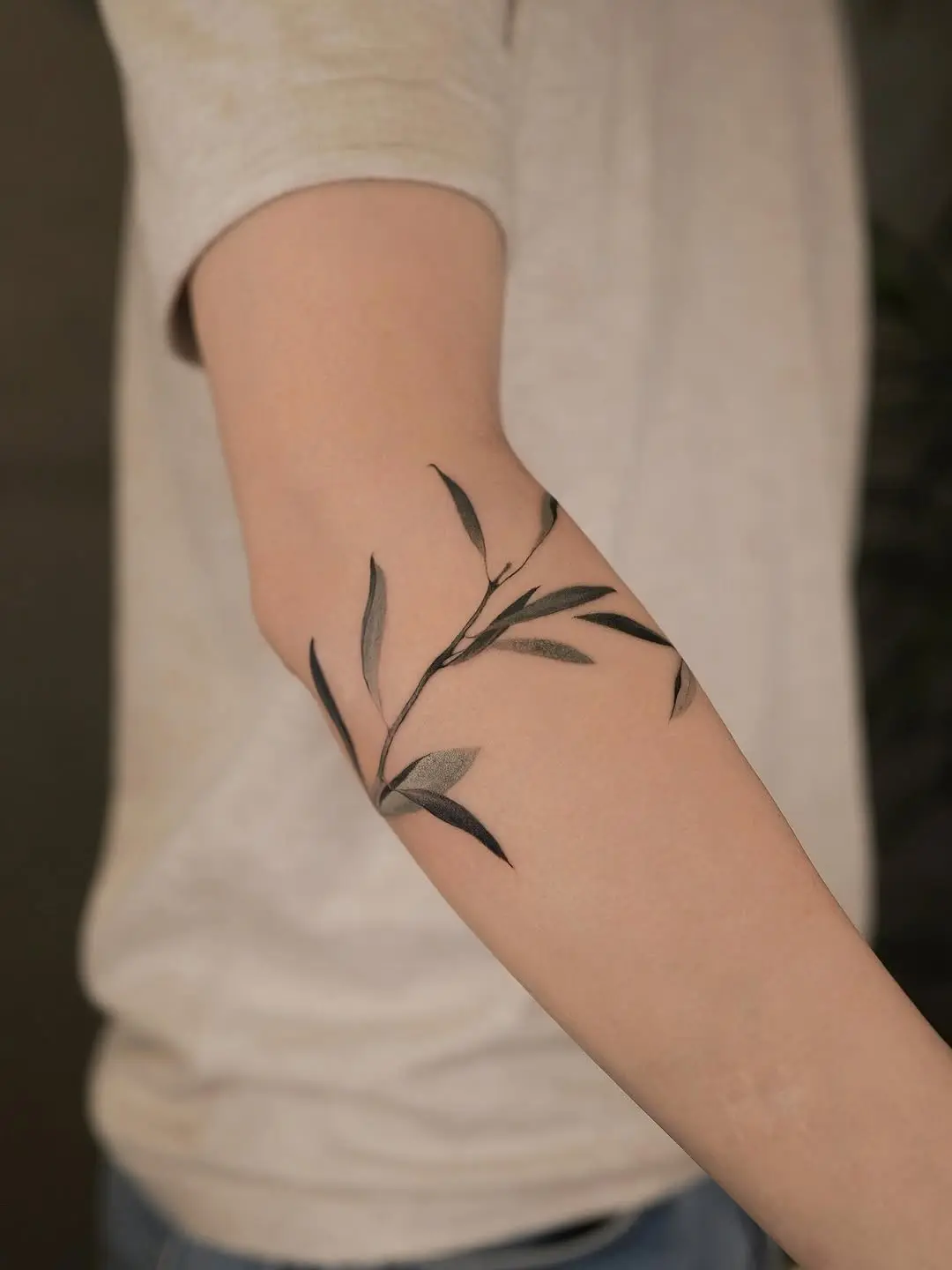 Elegant olive branch tattoo on forearm