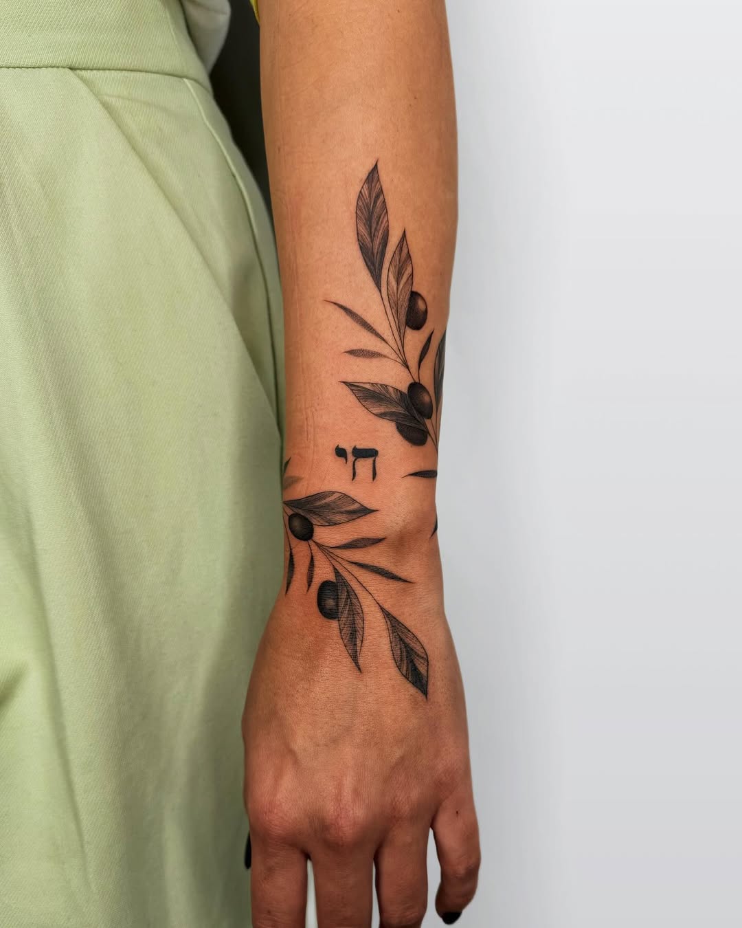 Elegant olive branch tattoo on arm