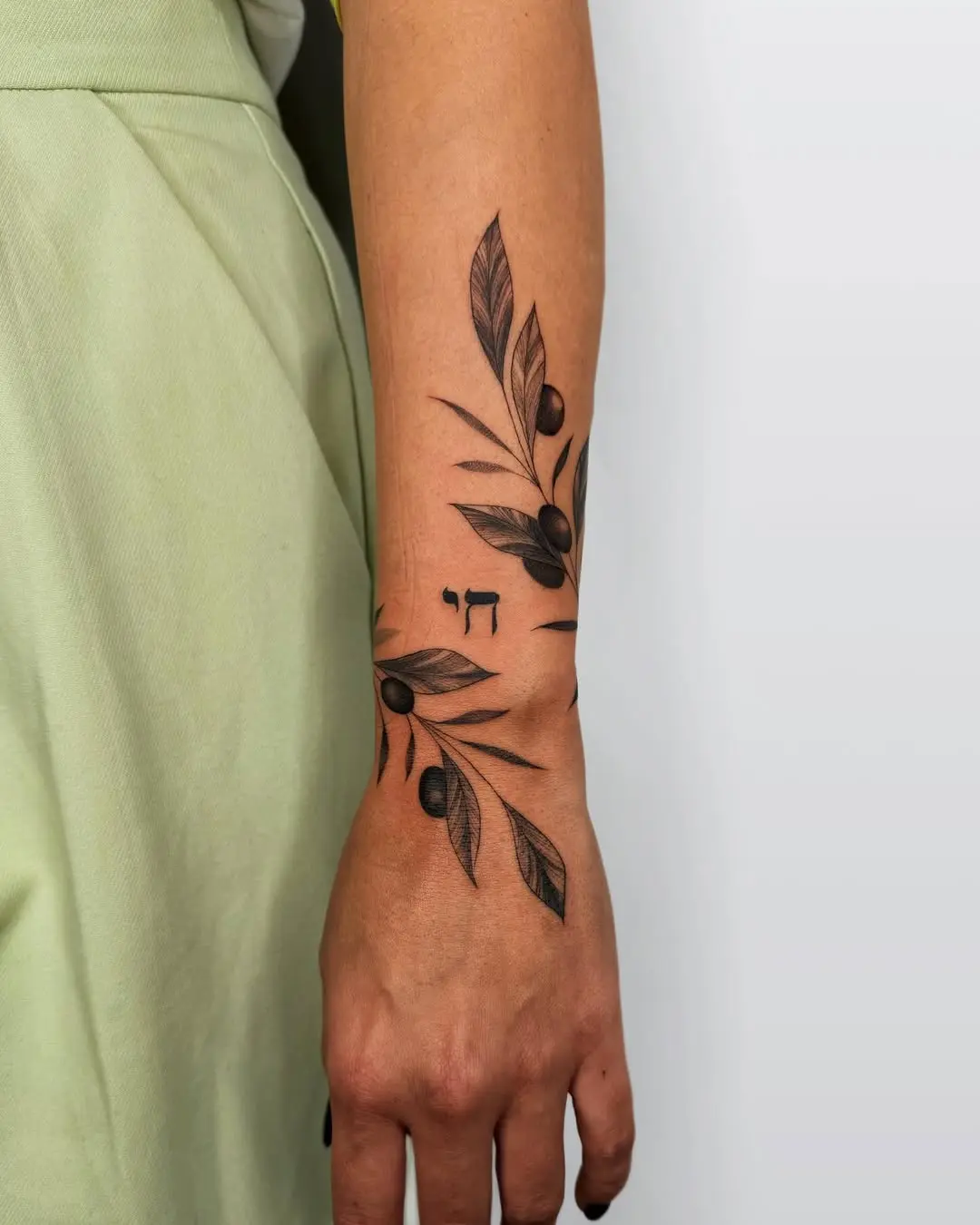 Elegant olive branch tattoo on arm