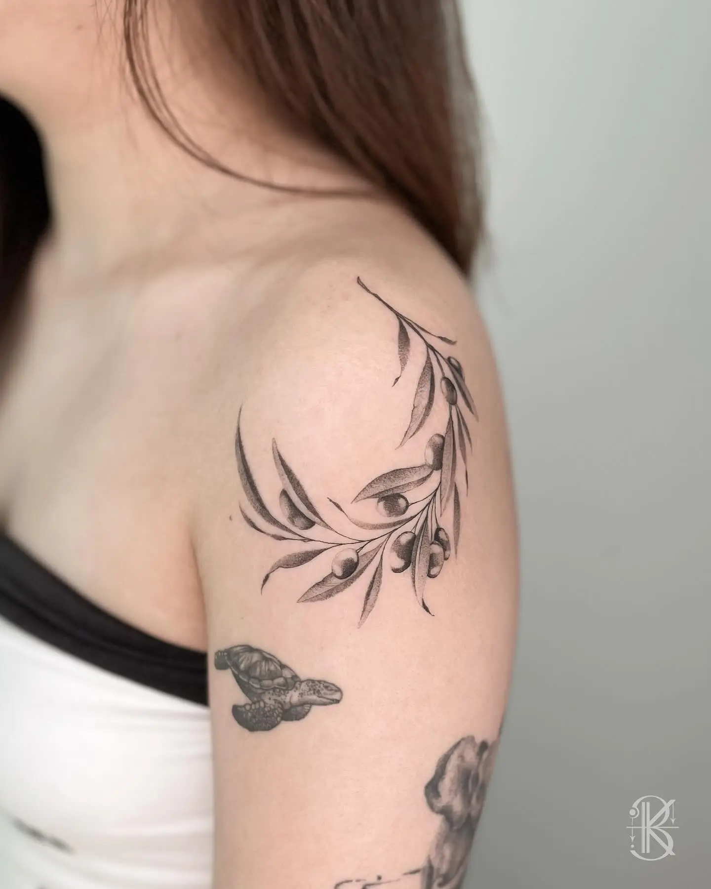 Elegant olive branch tattoo on shoulder