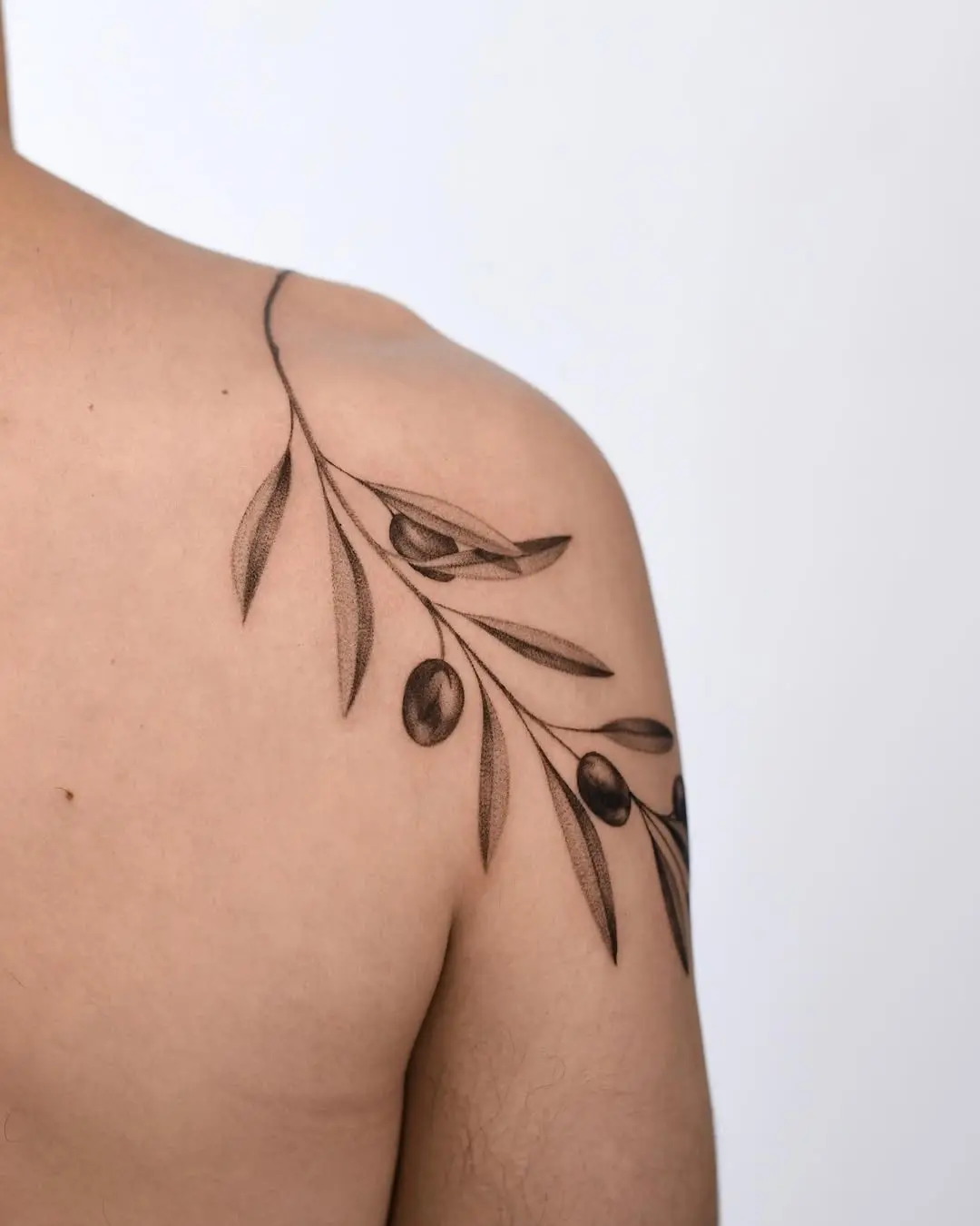 Elegant olive branch tattoo on shoulder