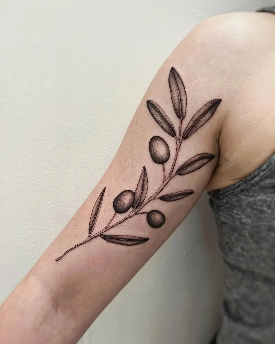 Stylish olive branch tattoo on the forearm
