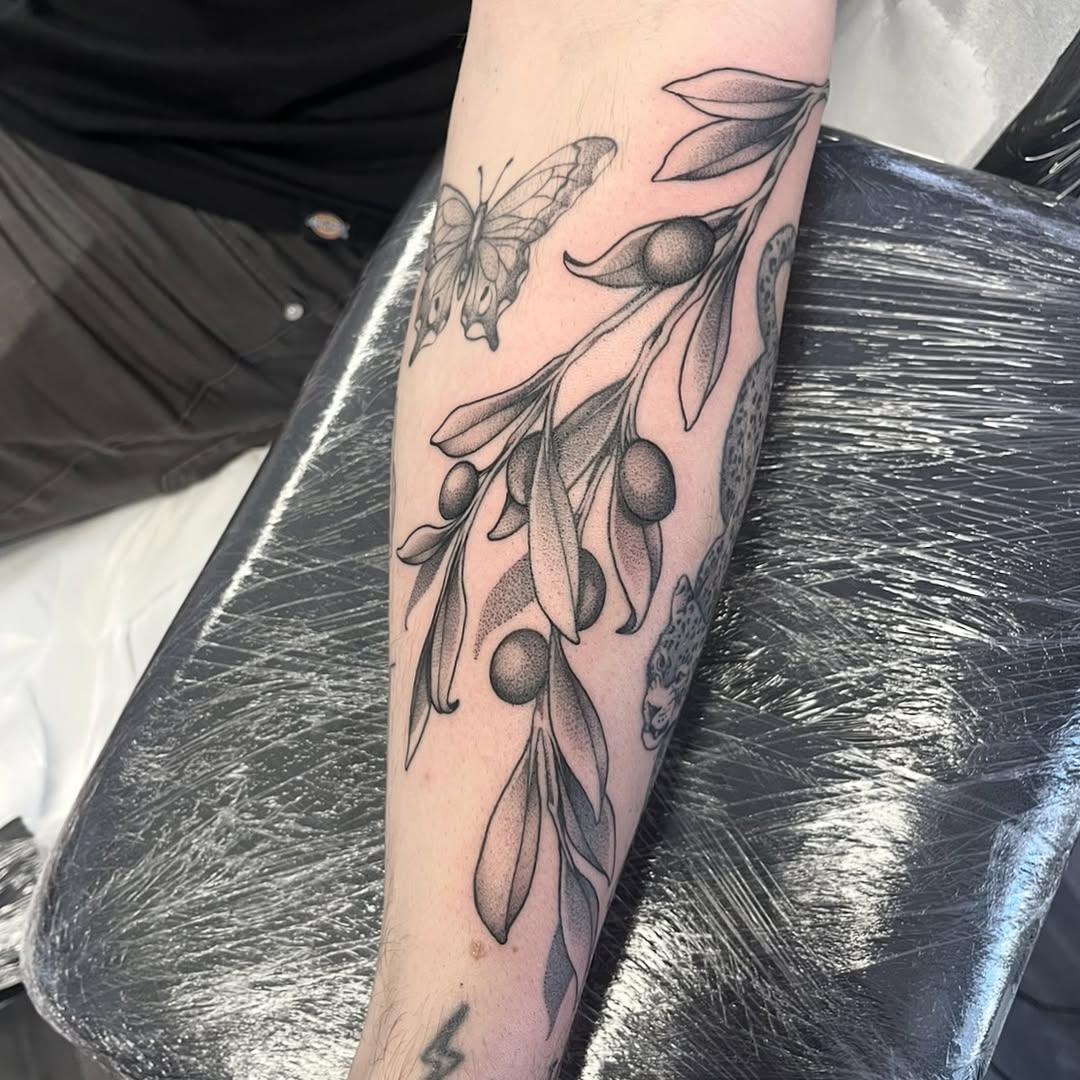 Elegant olive branch tattoo with butterfly detail