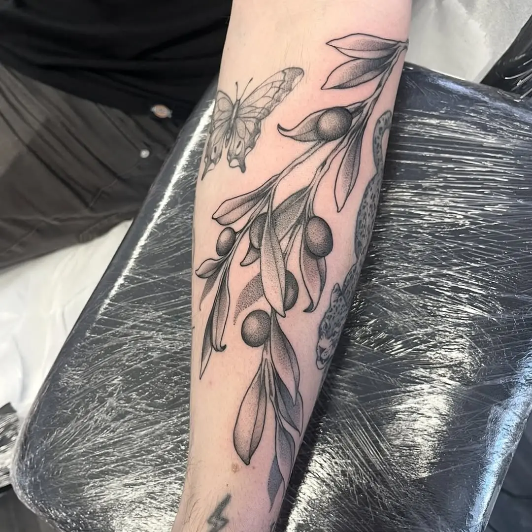 Elegant olive branch tattoo with butterfly detail