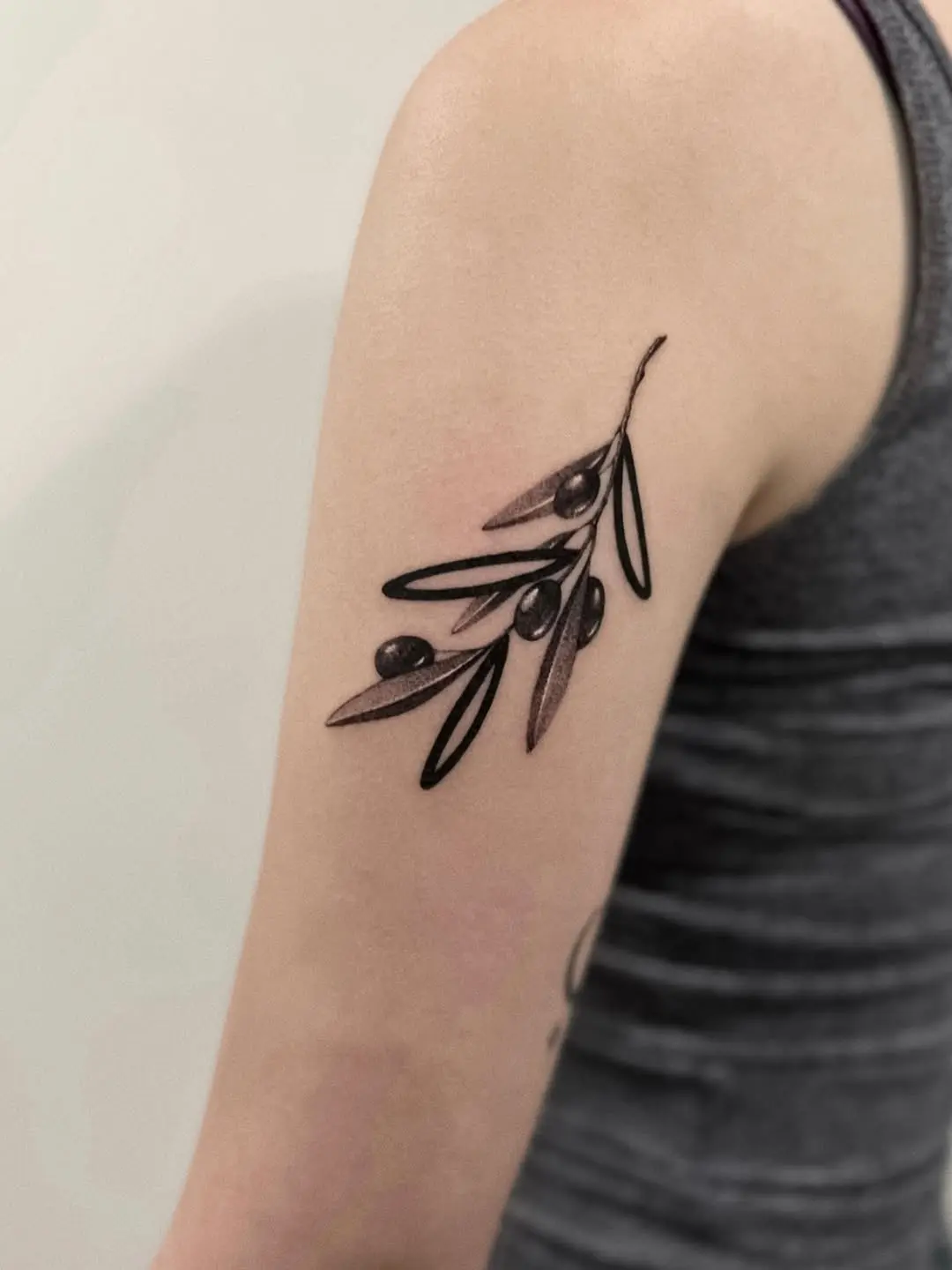 Elegant olive branch tattoo on graceful arm