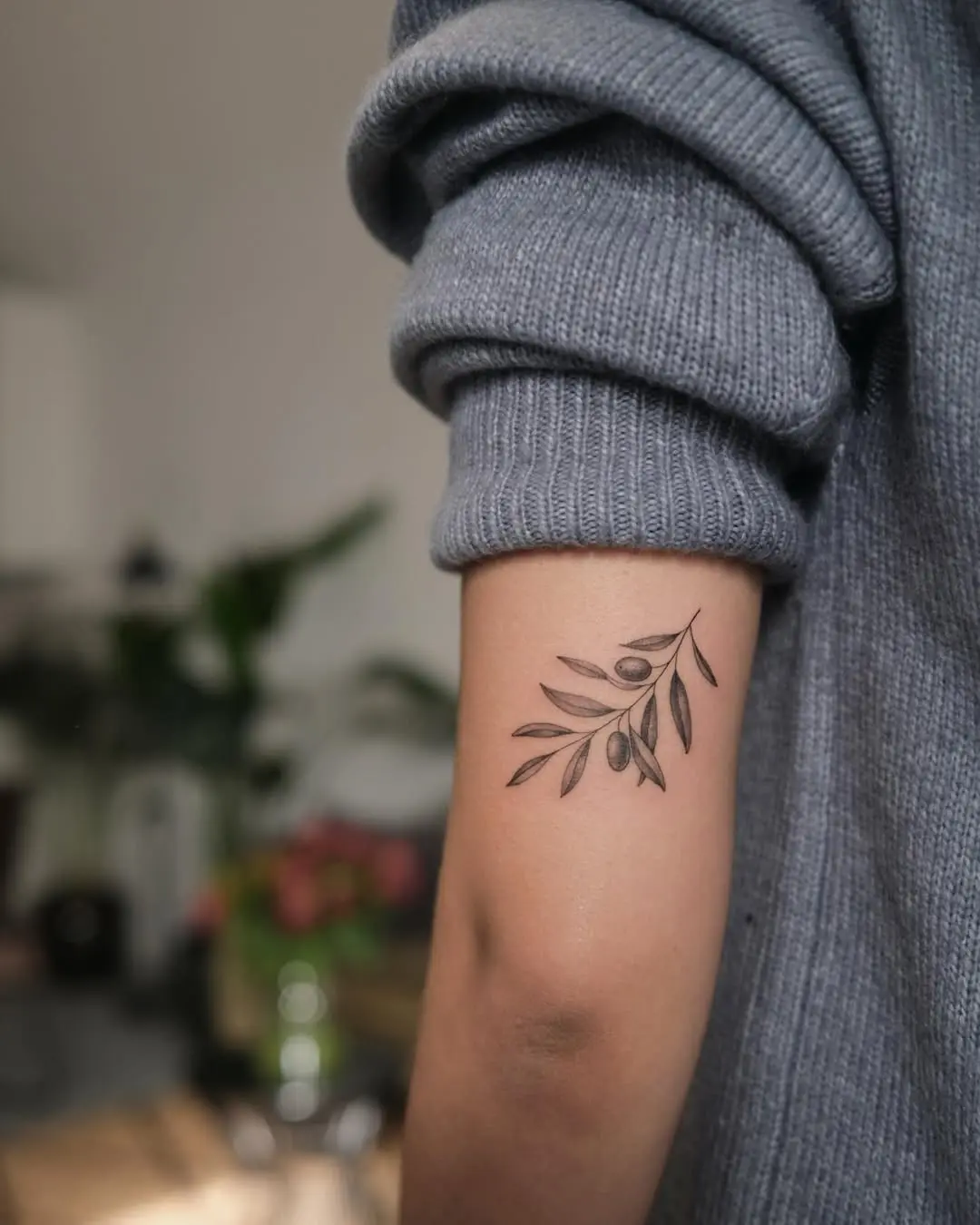 Elegant olive branch tattoo on the forearm