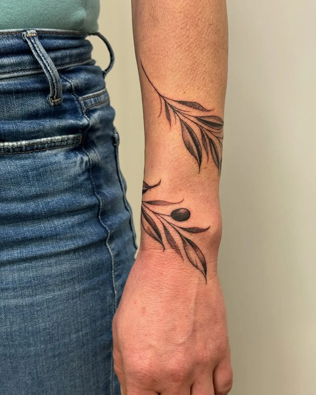 Elegant olive branch tattoo for subtle expression