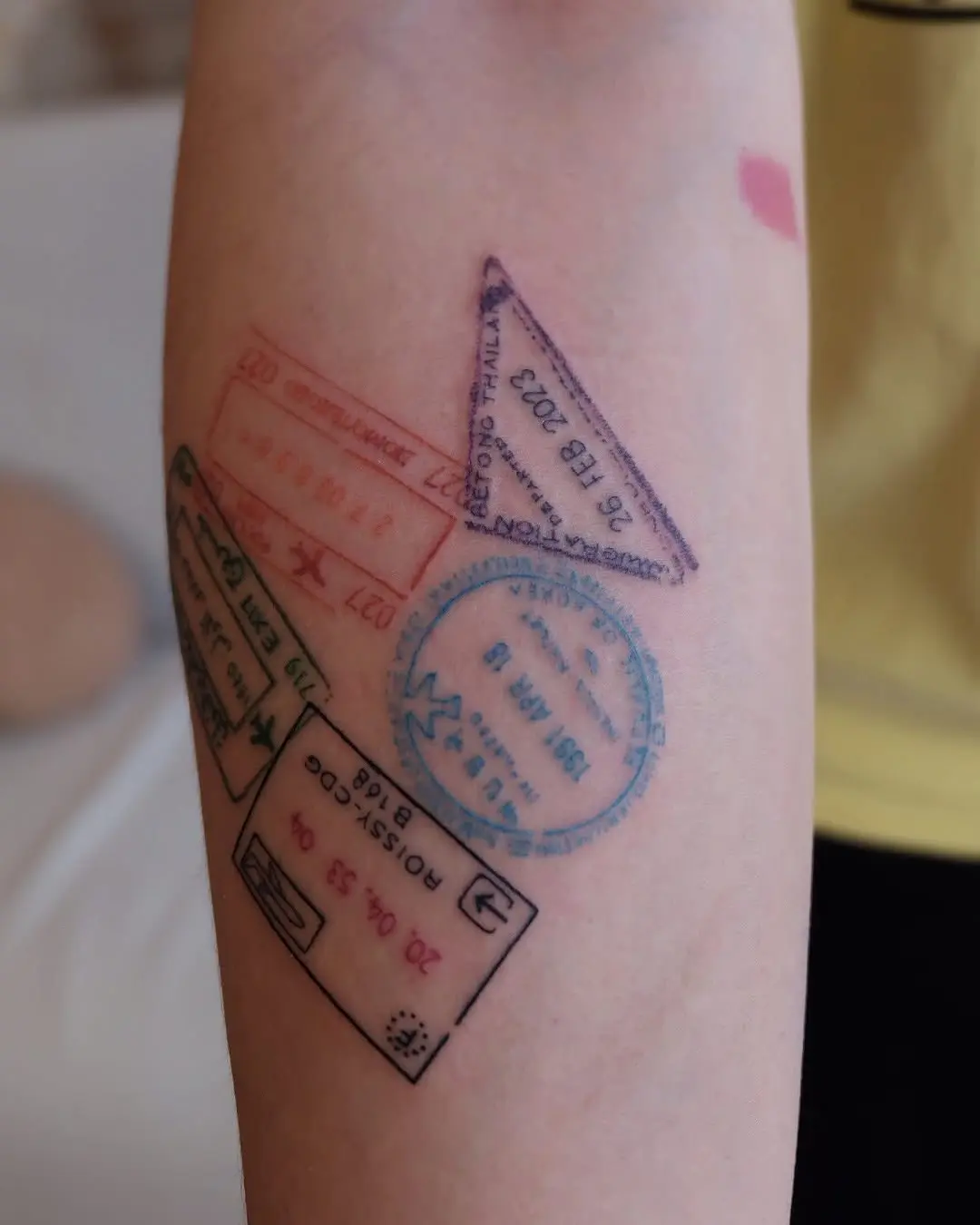 Colorful passport stamps inked on skin