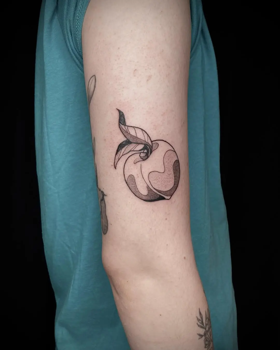 Stylish minimalist peach tattoo on the arm