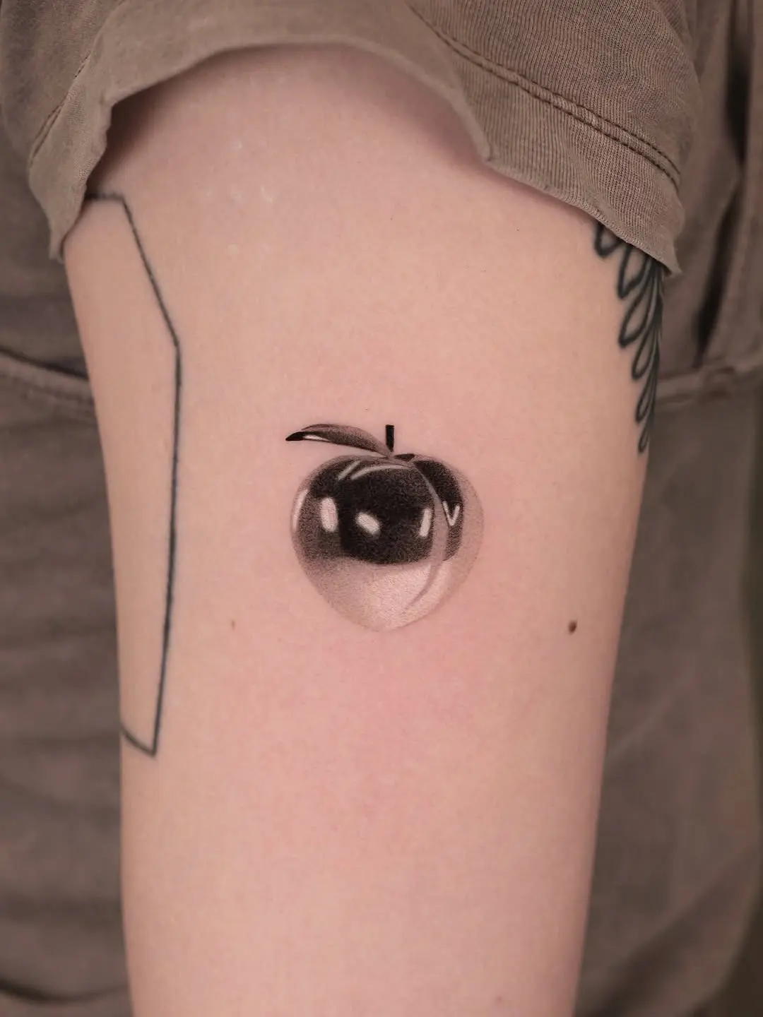 Stylish peach tattoo with a reflective vibe