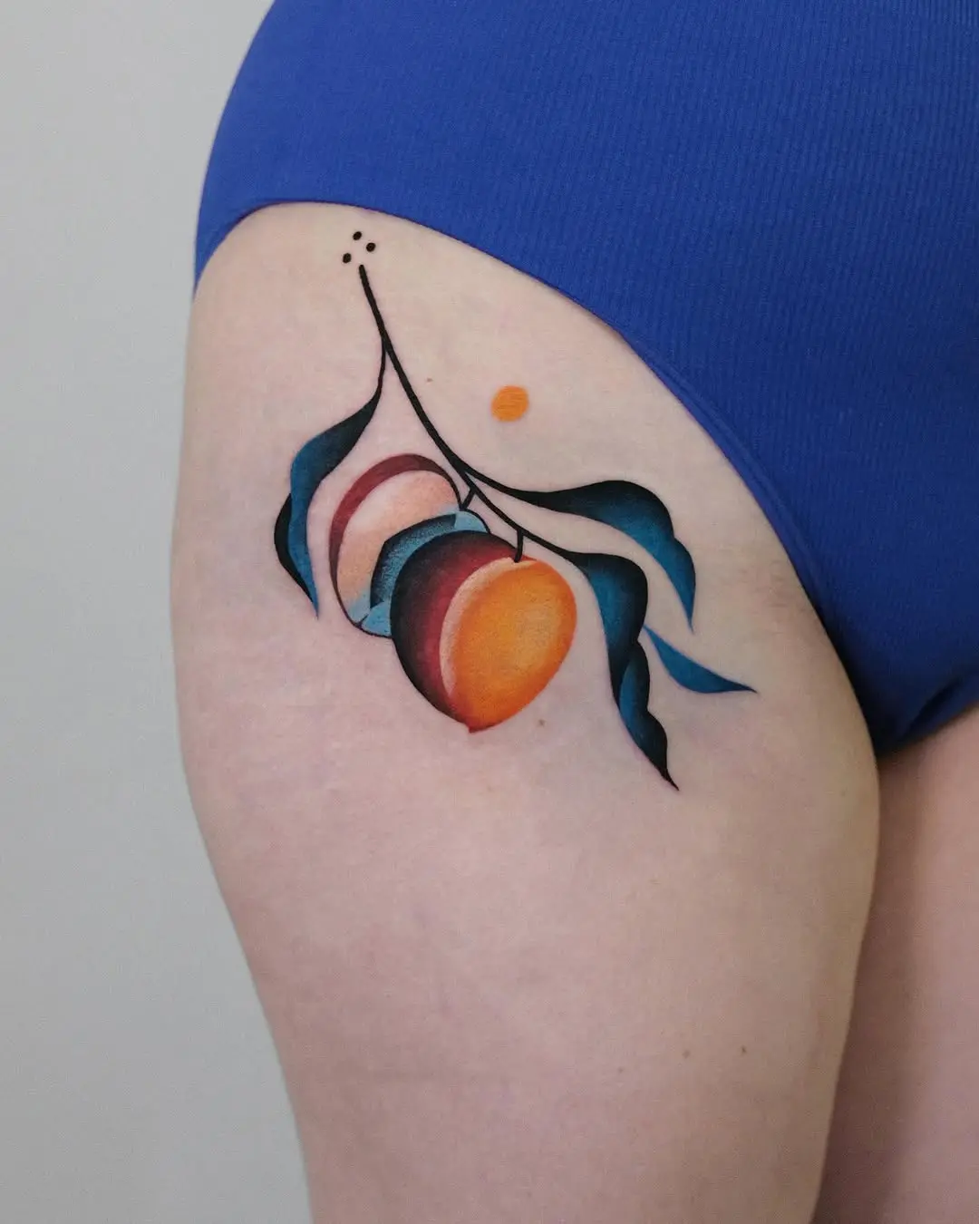 Vibrant peach tattoo with artistic leaves