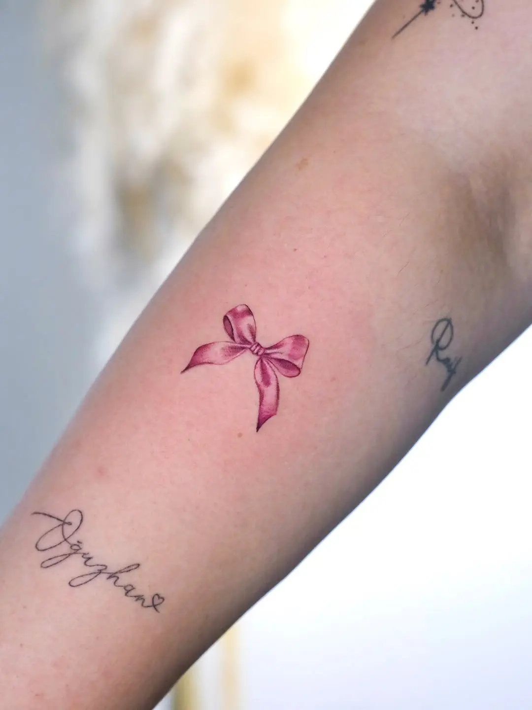 Charming pink bow tattoo on the arm