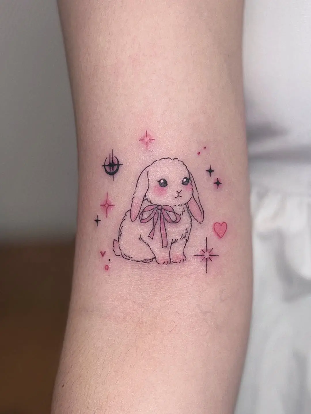 Charming pink bunny tattoo with whimsical stars