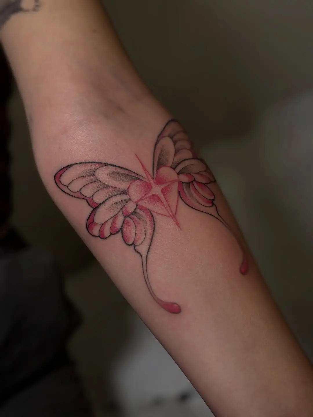 Elegant pink butterfly tattoo with delicate details