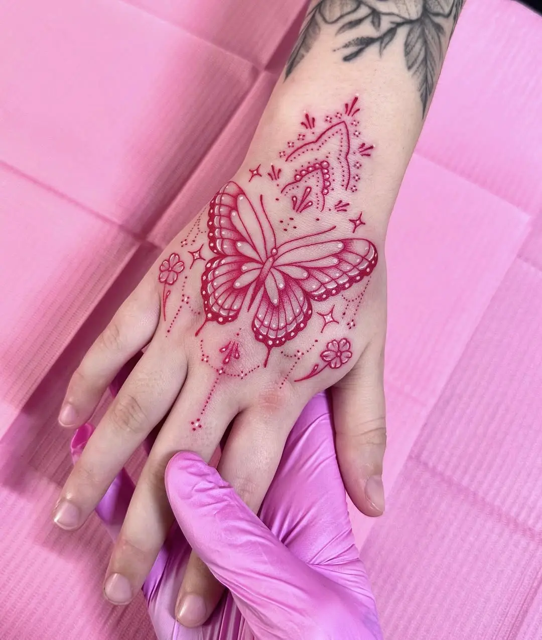 Vibrant pink butterfly hand tattoo design