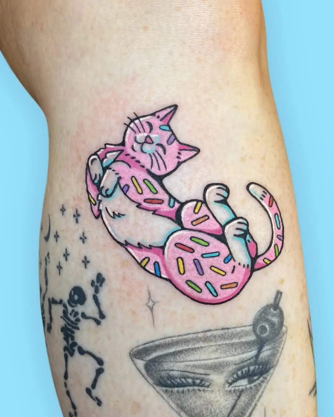 Cute cat tattoo with playful sprinkles design