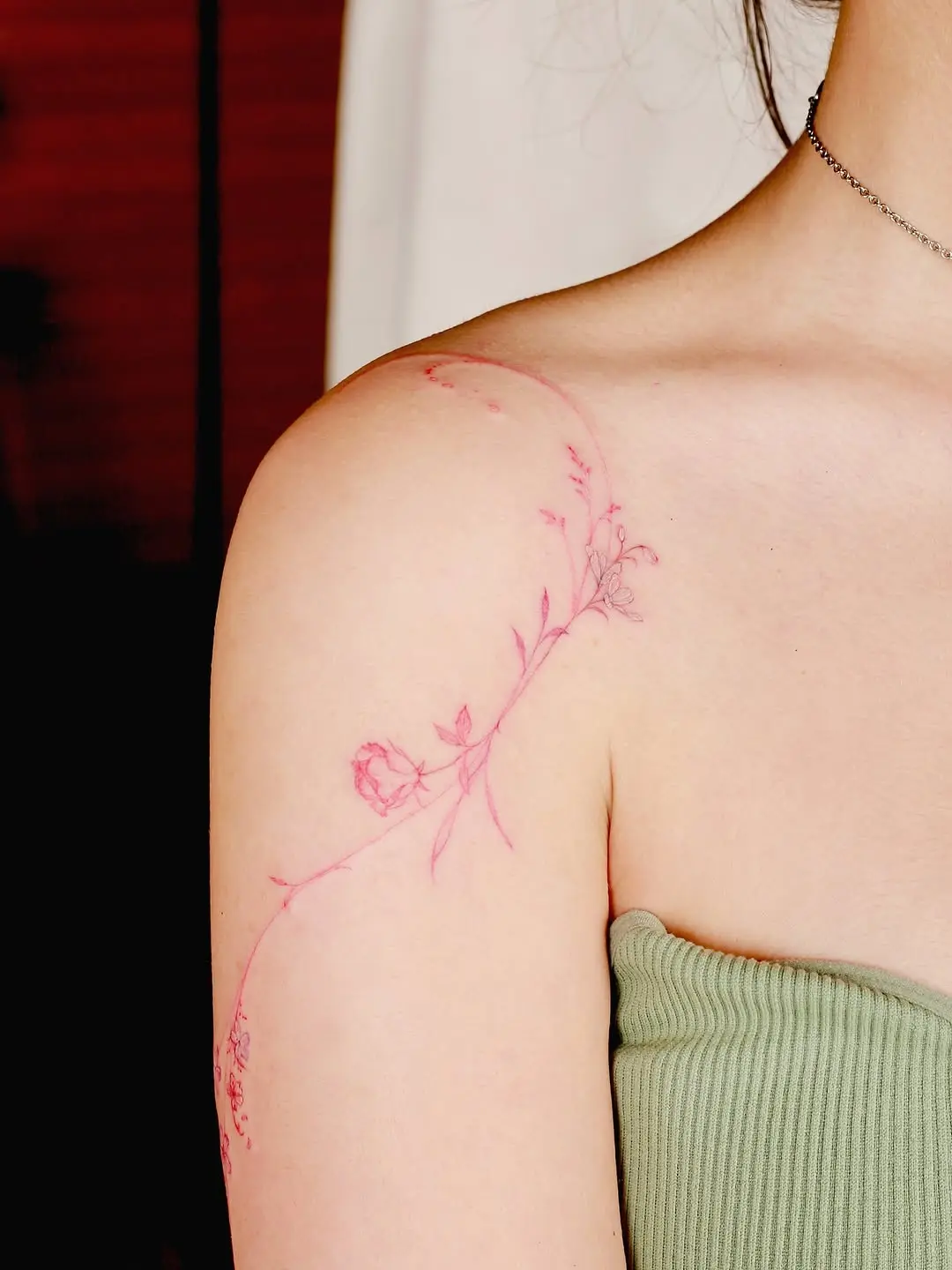 Delicate pink floral tattoo on the arm