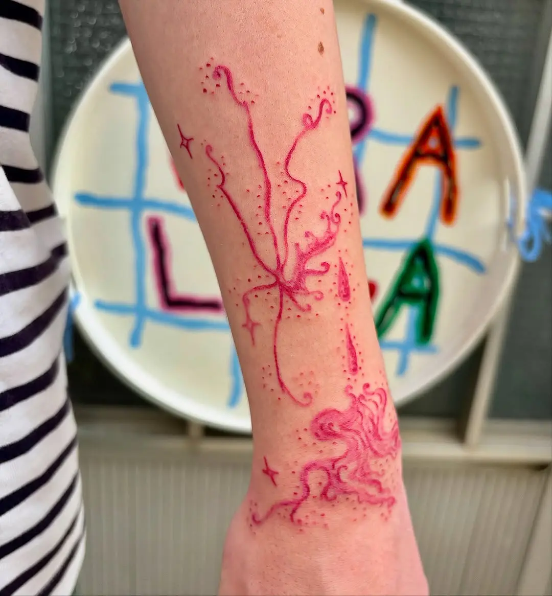 Artistic pink tattoo with intricate swirling designs
