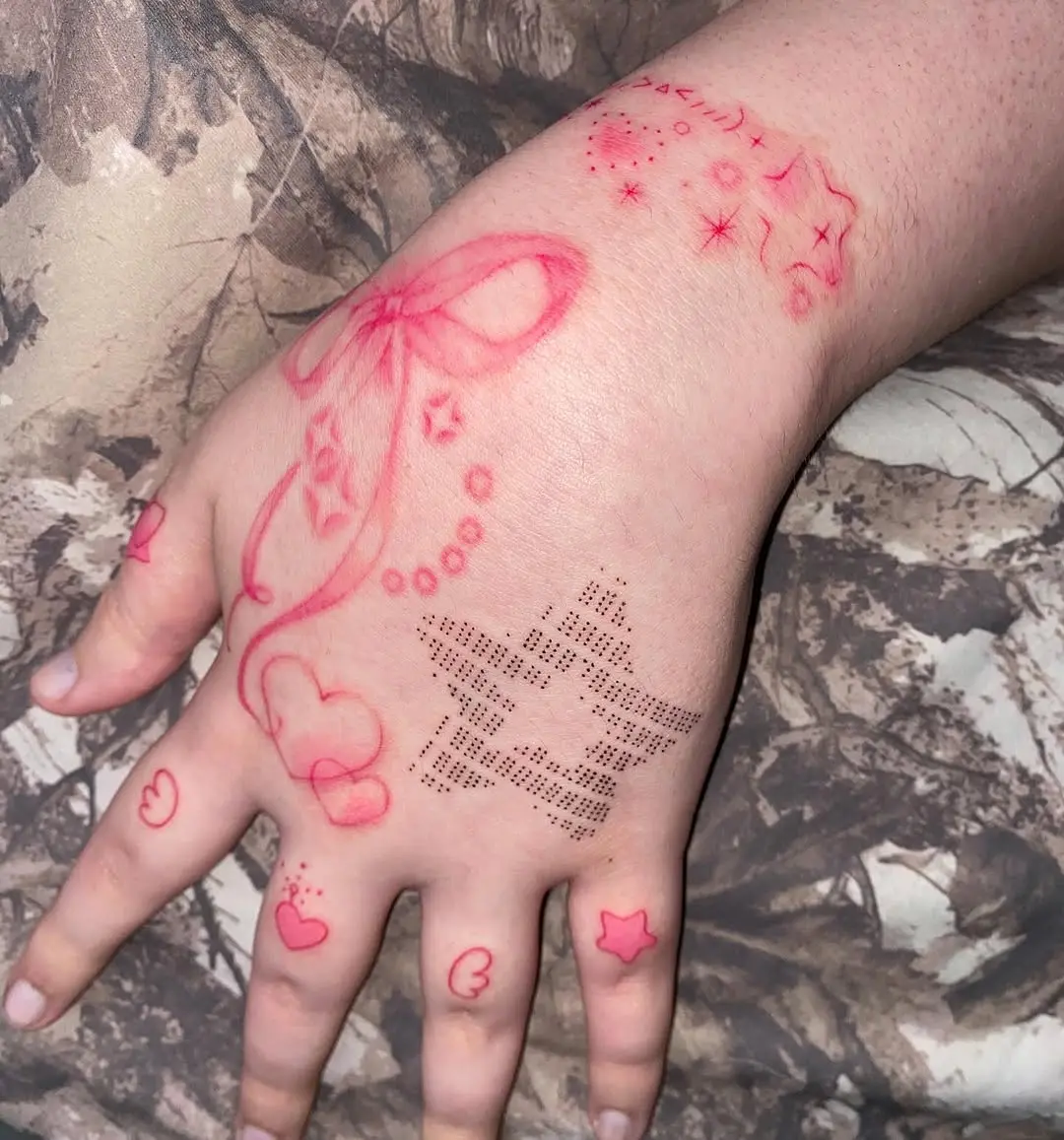 Whimsical pink tattoo designs on hand