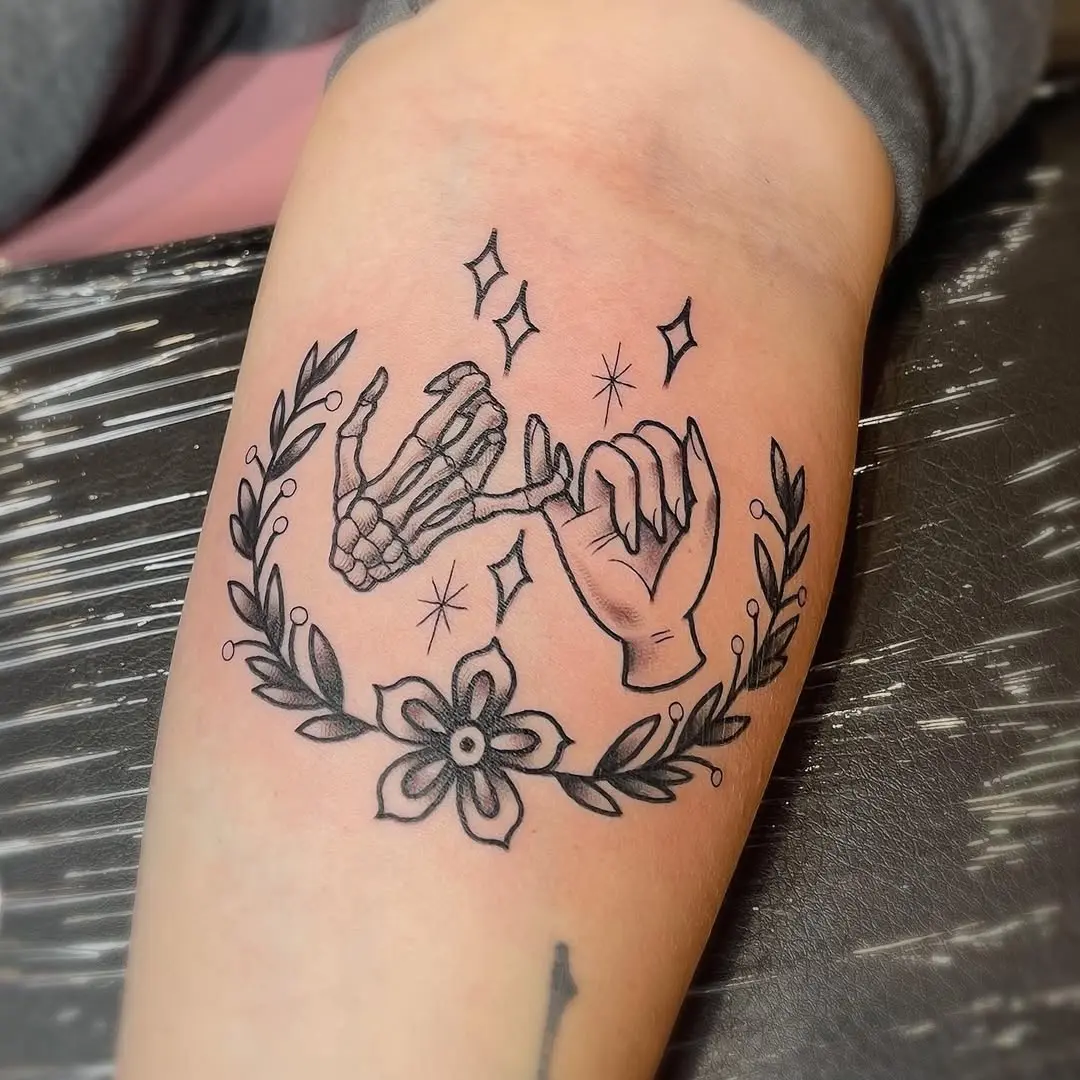 Unique pinky promise tattoo with floral accents