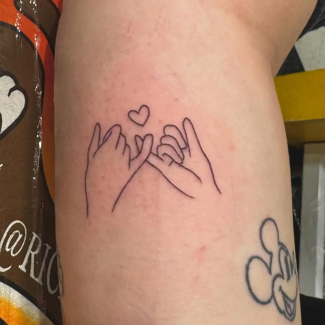 Delicate pinky promise tattoo with heart design