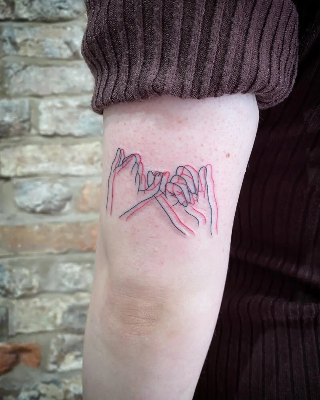 Intricate pinky promise tattoo design in red ink