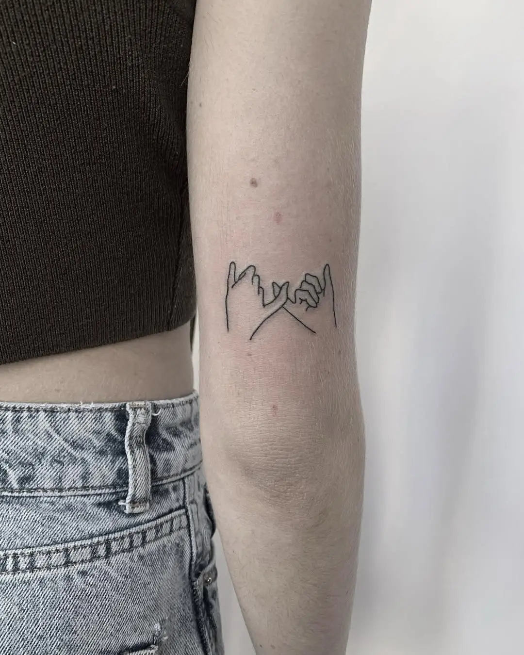 Meaningful pinky promise tattoo in minimalist style