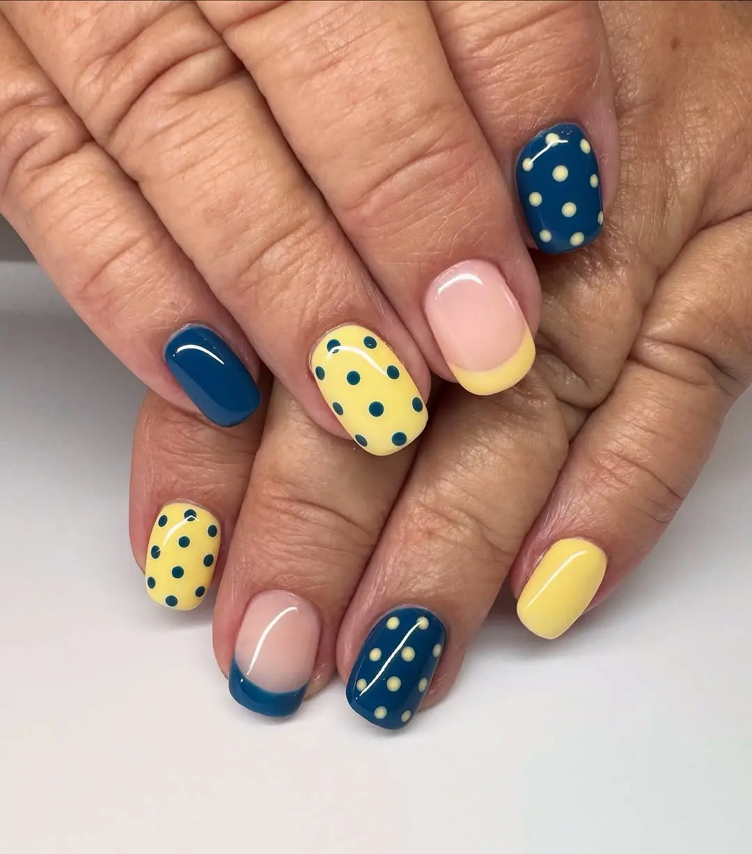 Vibrant blue and yellow polka dot nails