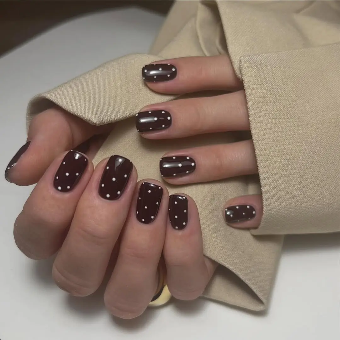 Chic burgundy nails with playful polka dots