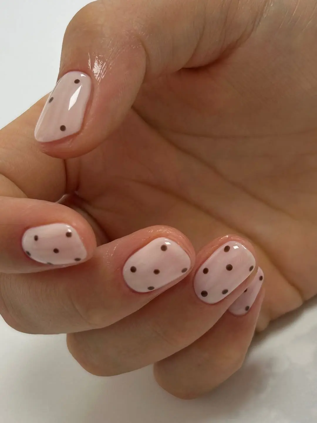 Chic light pink nails with brown polka dots