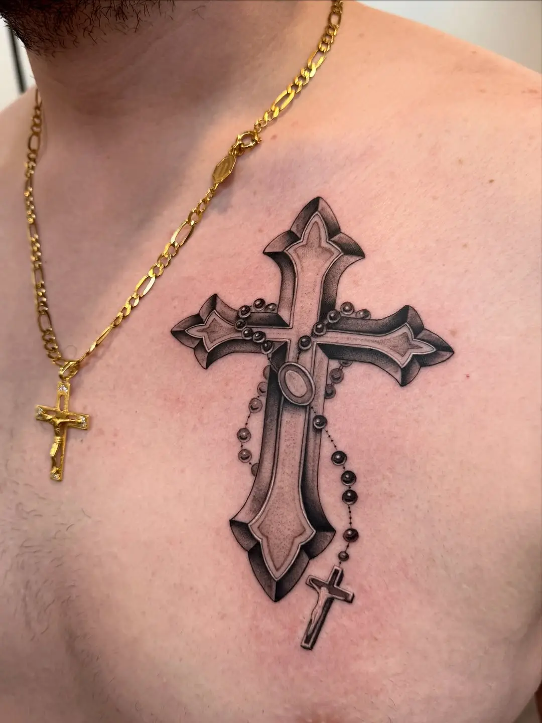 Intricate rosary cross tattoo on the chest