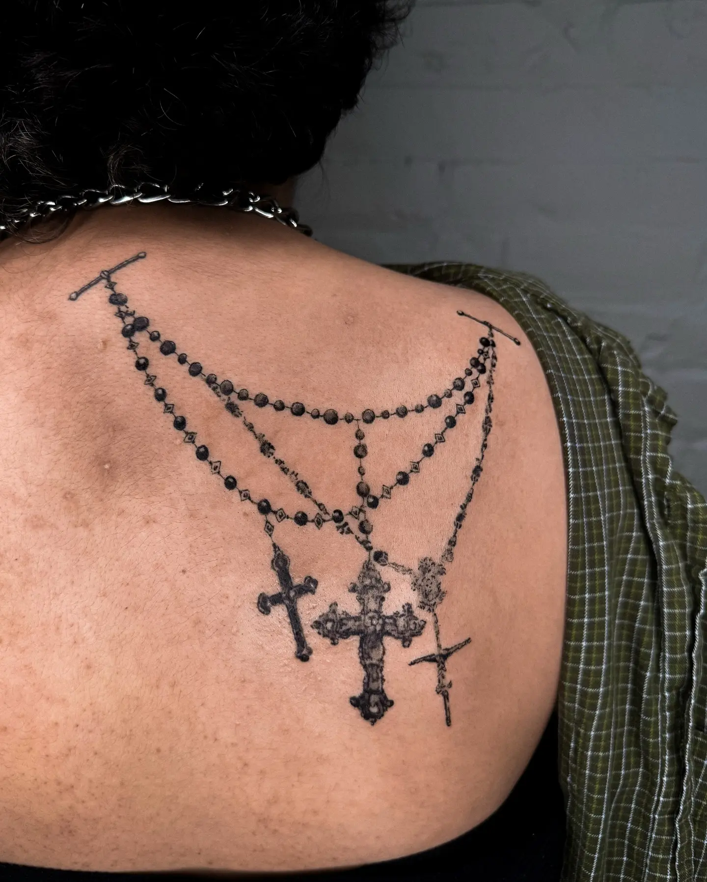 Elegant rosary tattoo showcasing intricate crosses