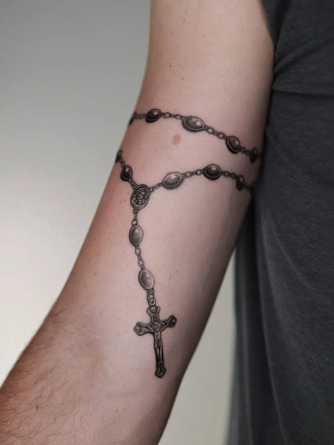 Stunning rosary tattoo wrapped around the arm