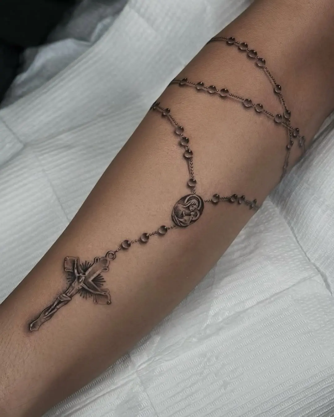 Elegant arm rosary tattoo showcasing intricate details