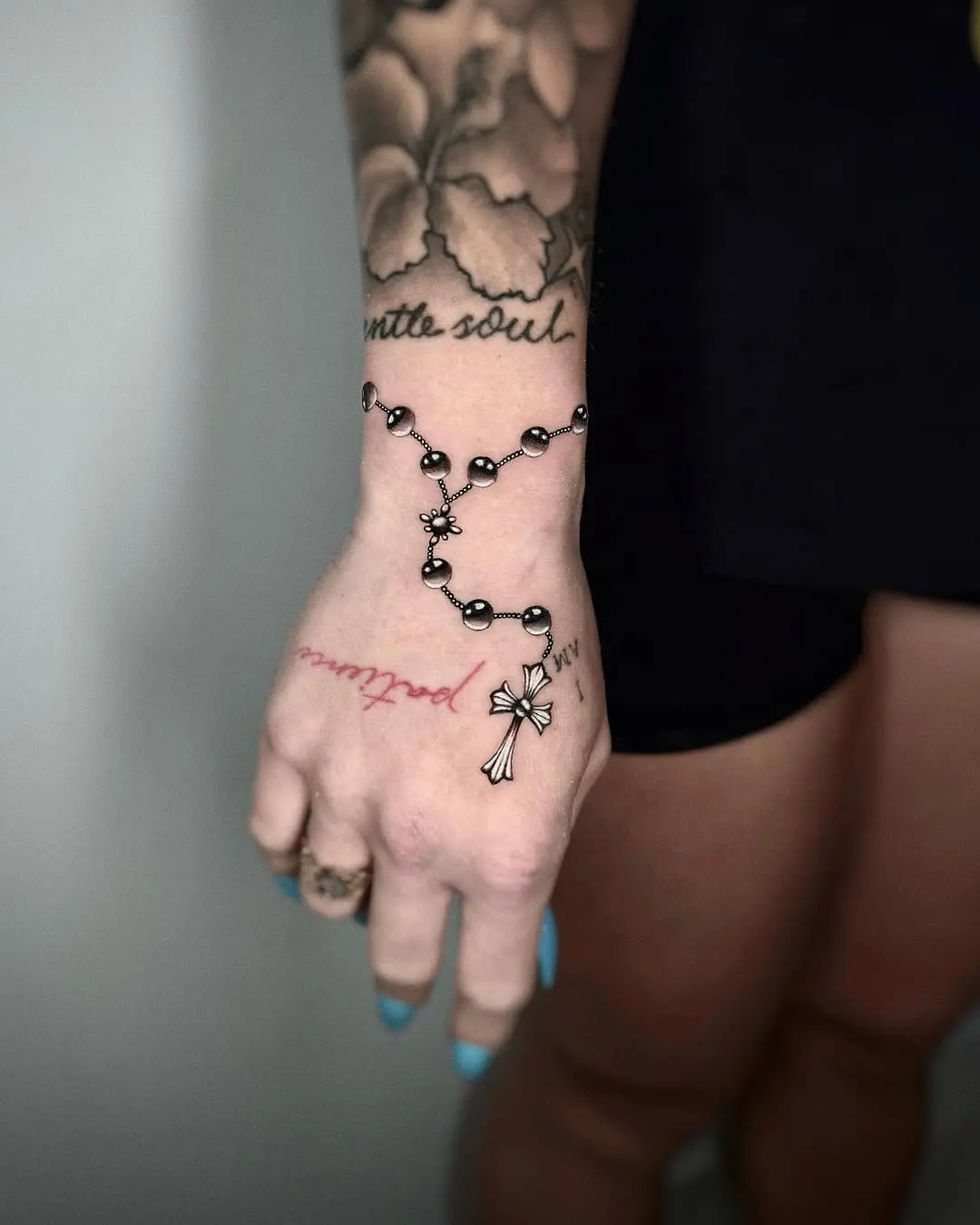 Elegant rosary tattoo wrapping around the wrist
