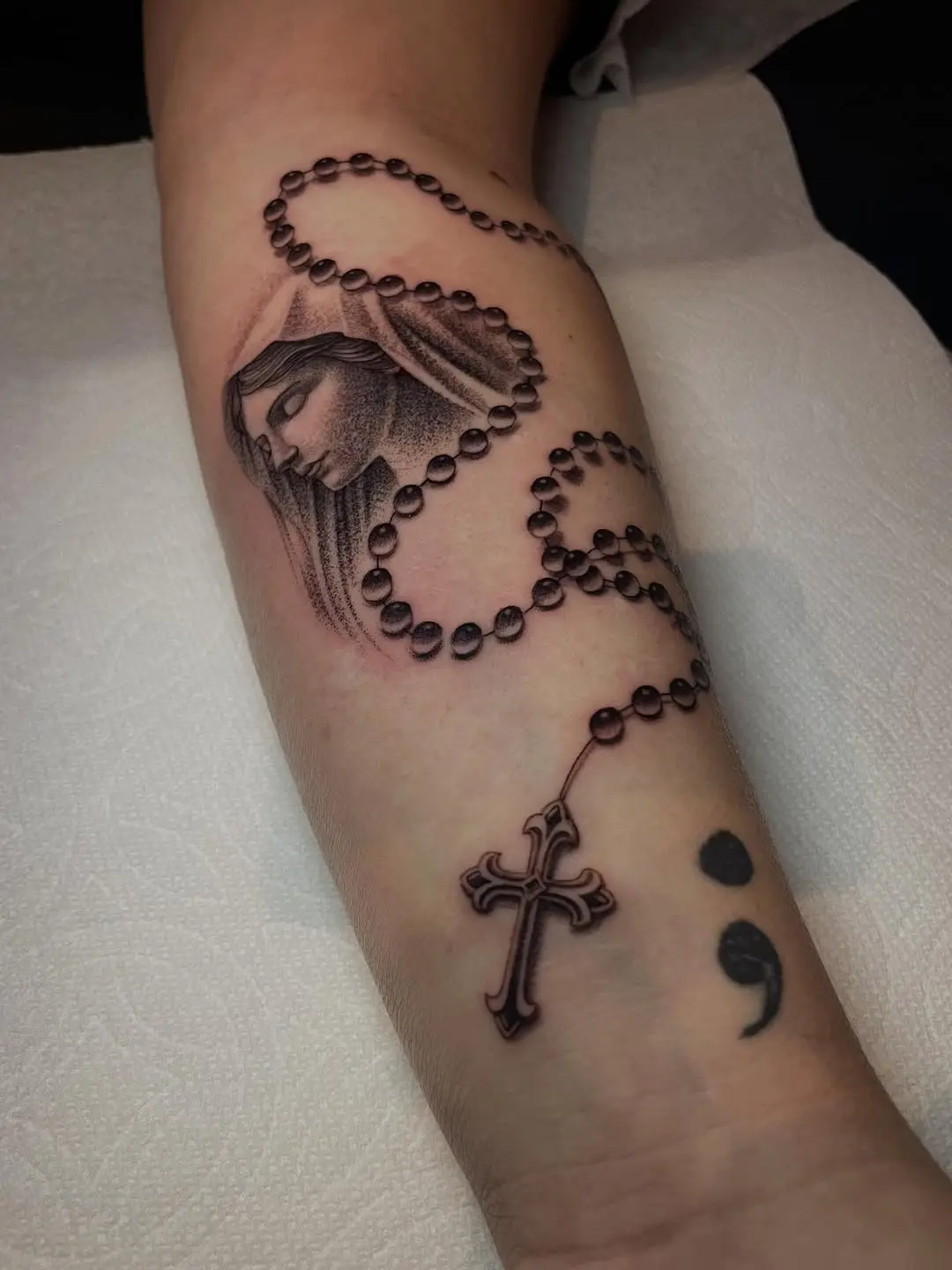 Elegant rosary tattoo with a divine touch