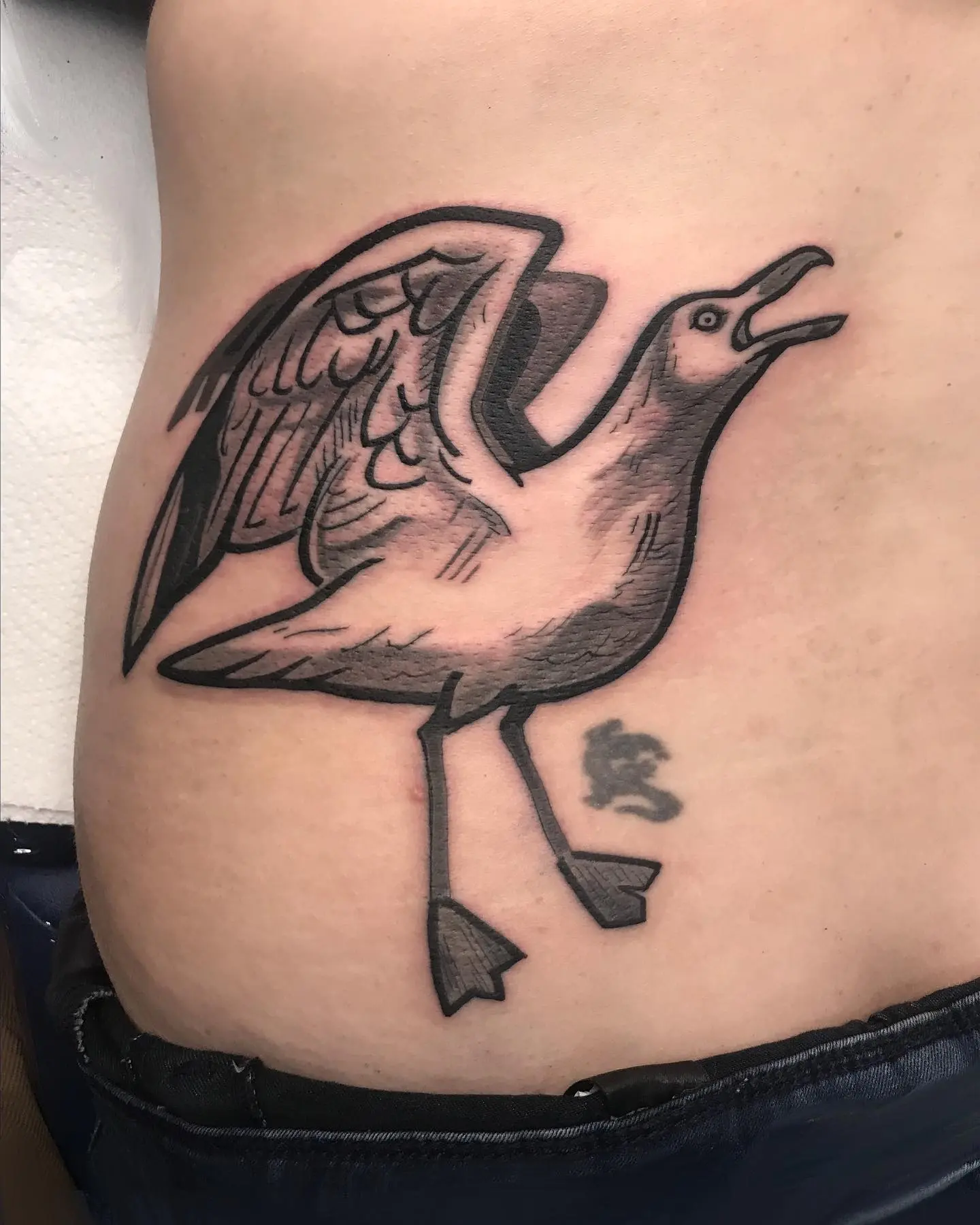 Expressive seagull tattoo in dynamic pose