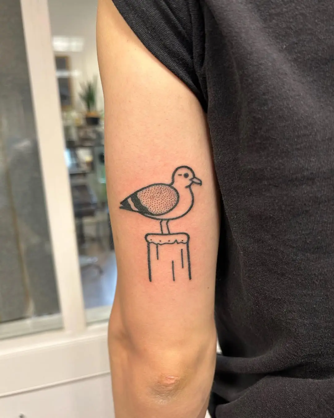 Minimalist seagull tattoo on a vintage pillar