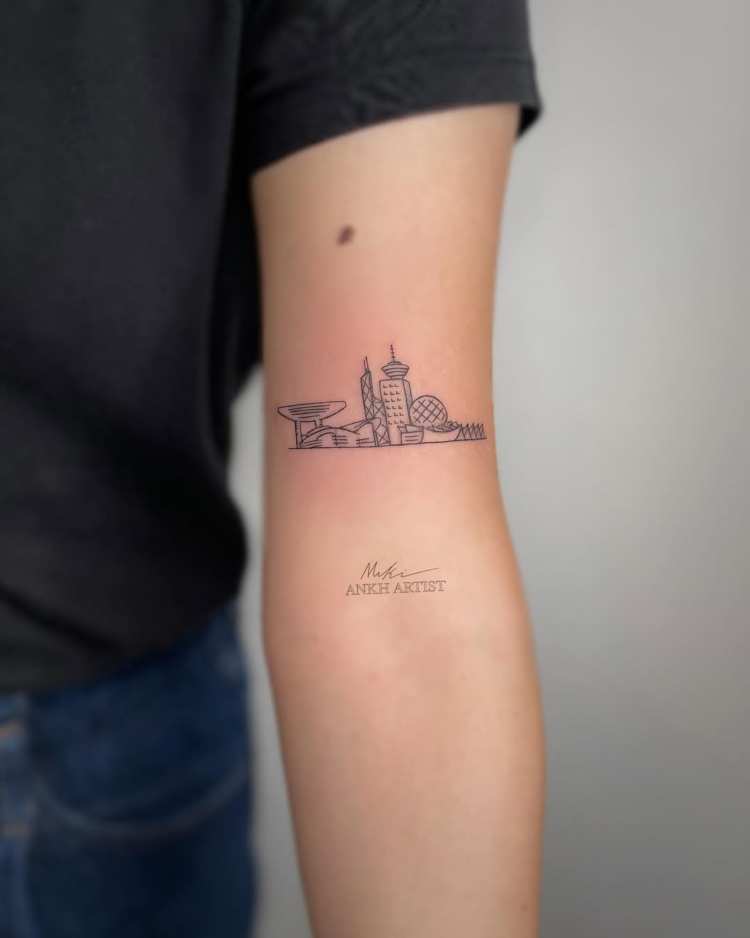 Minimalist skyline tattoo on the forearm