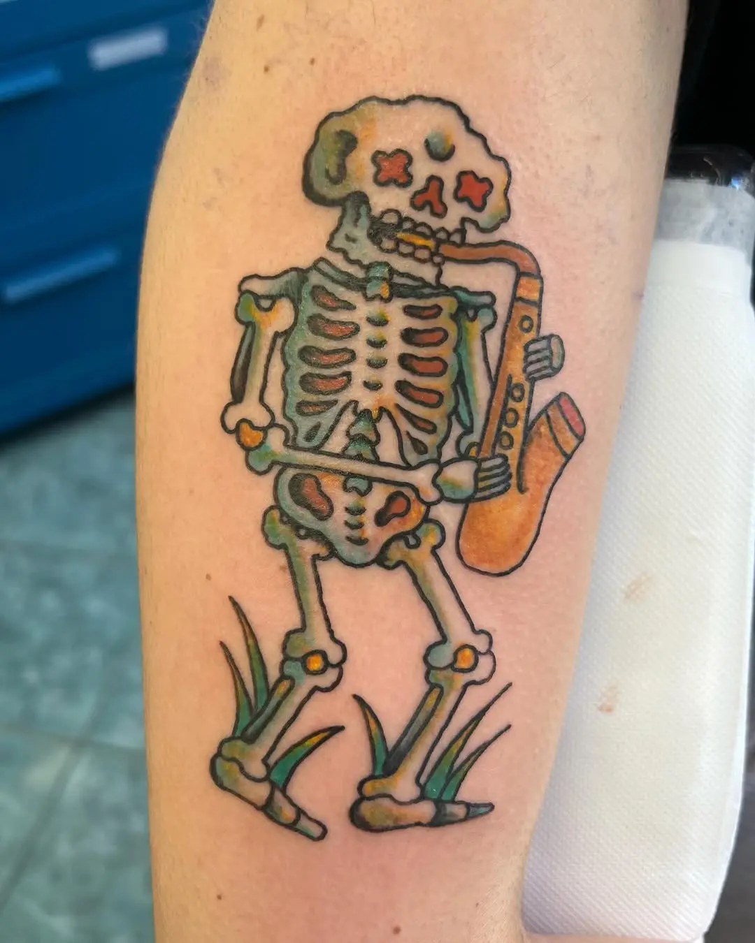 Whimsical skeleton playing saxophone tattoo