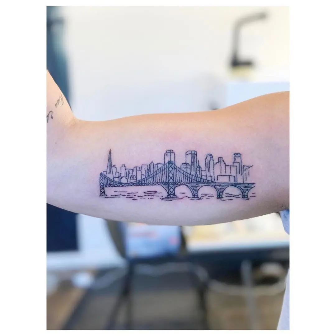 Intricate skyline tattoo featuring city bridges