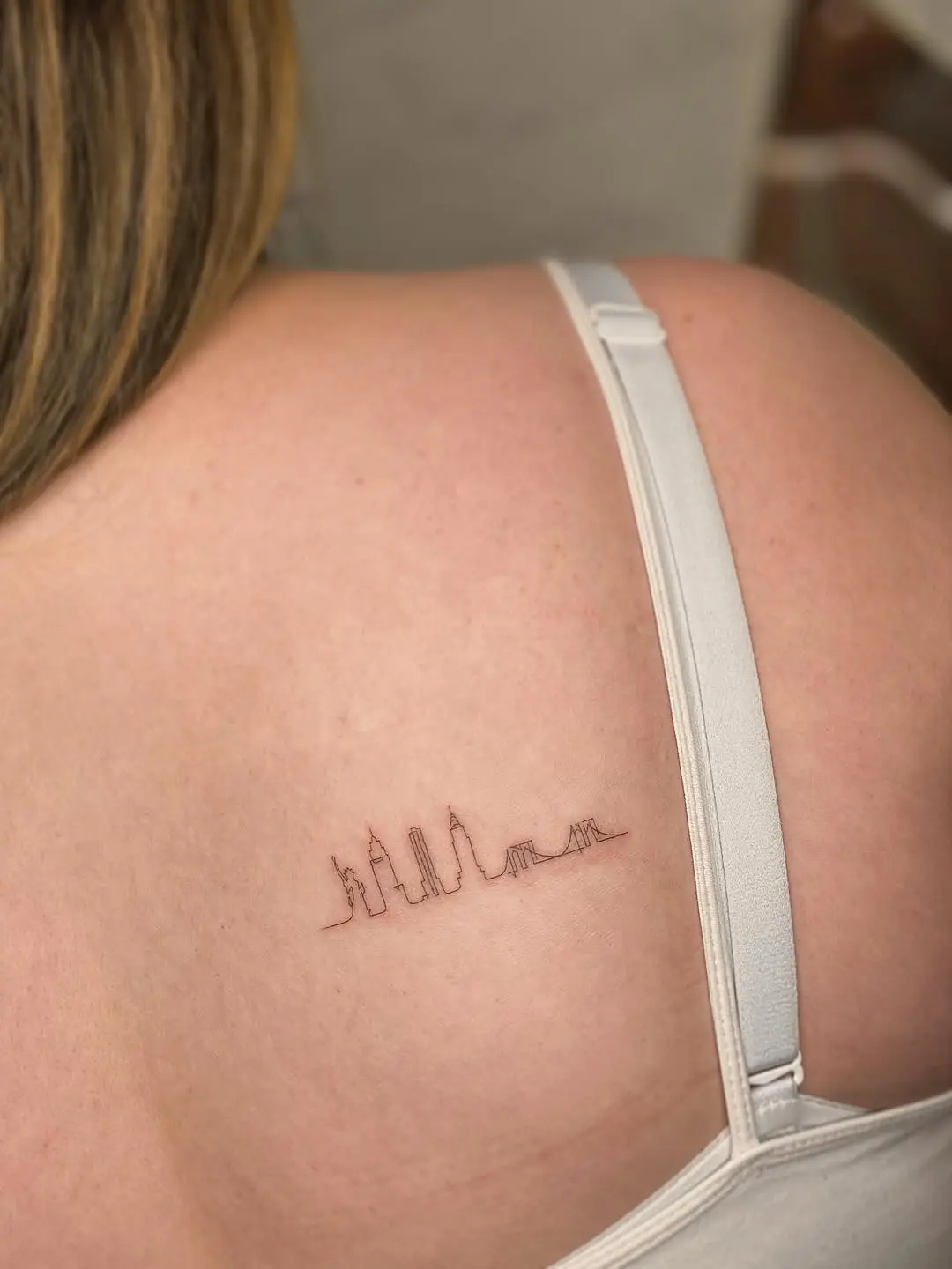 Minimalist skyline tattoo on shoulder