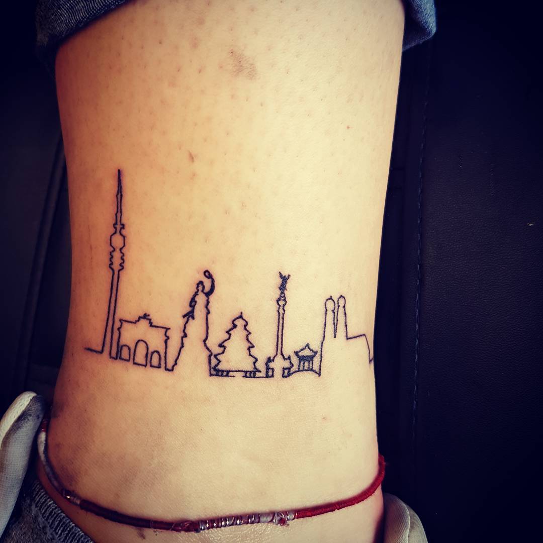 Minimalist skyline tattoo with iconic structures