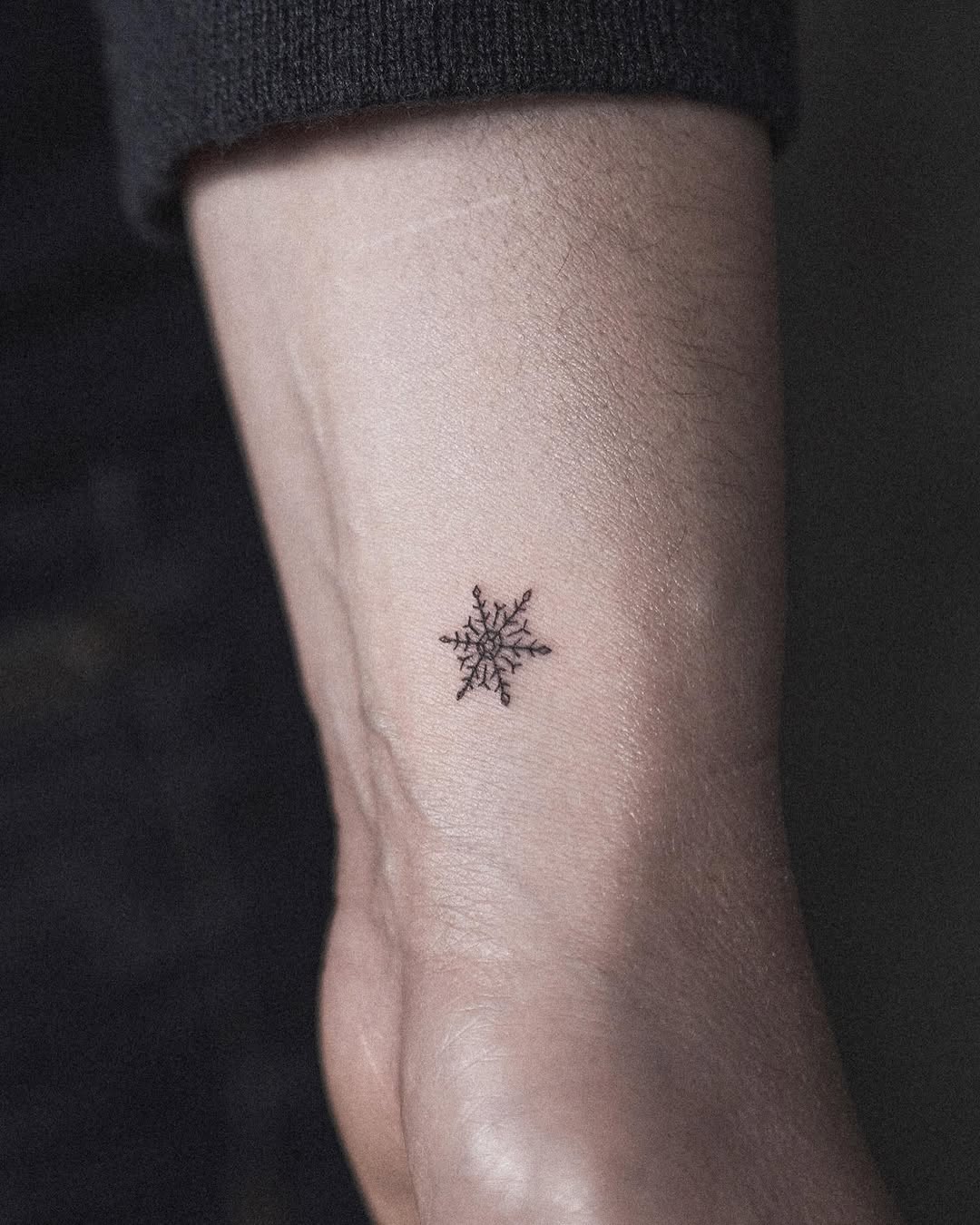 Elegant small snowflake tattoo on wrist