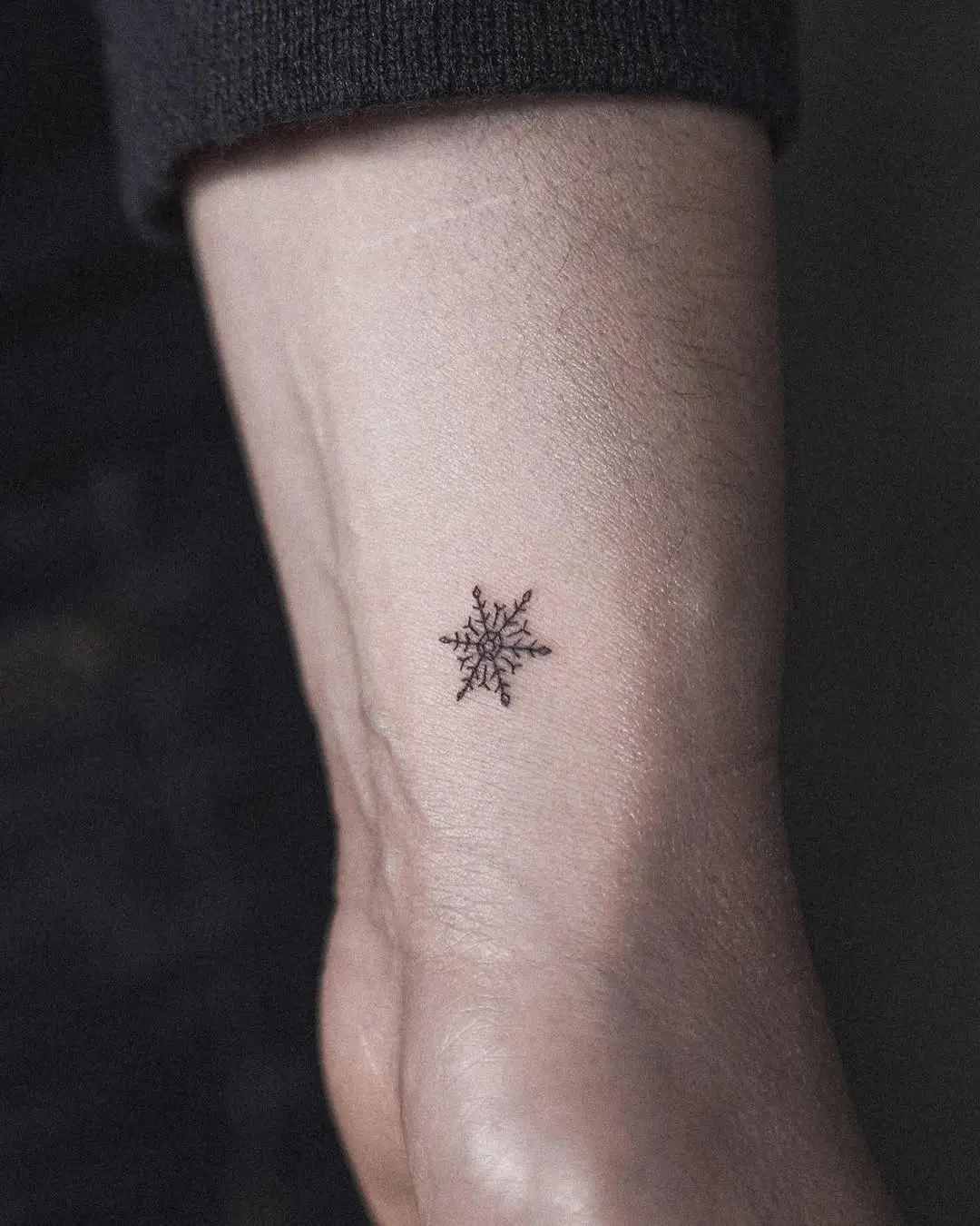 Elegant small snowflake tattoo on wrist