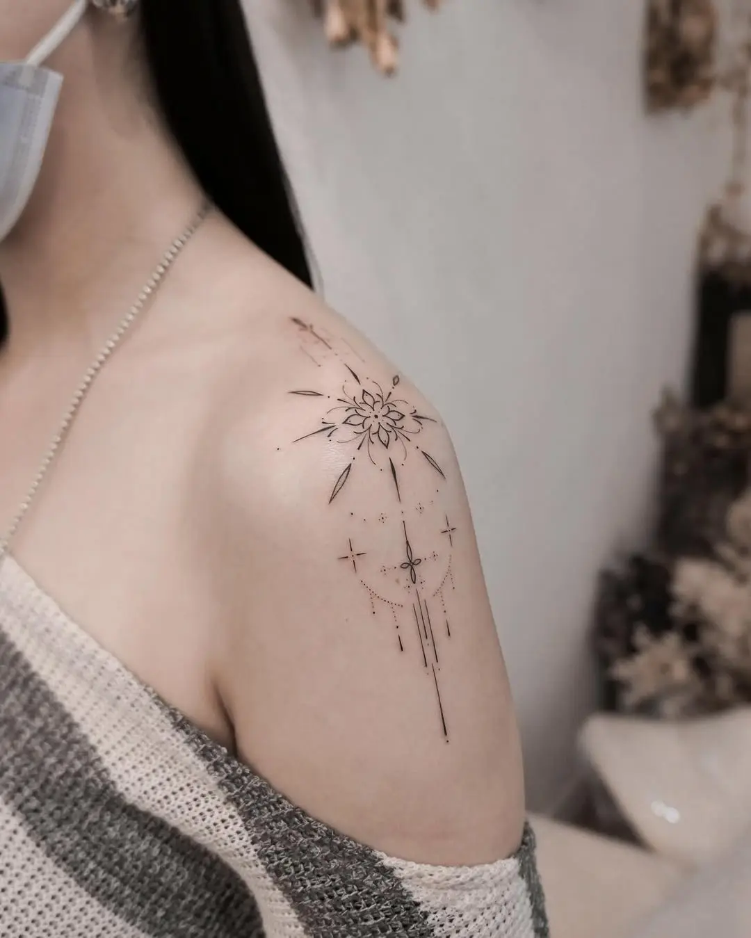 Delicate snowflake design on shoulder tattoo