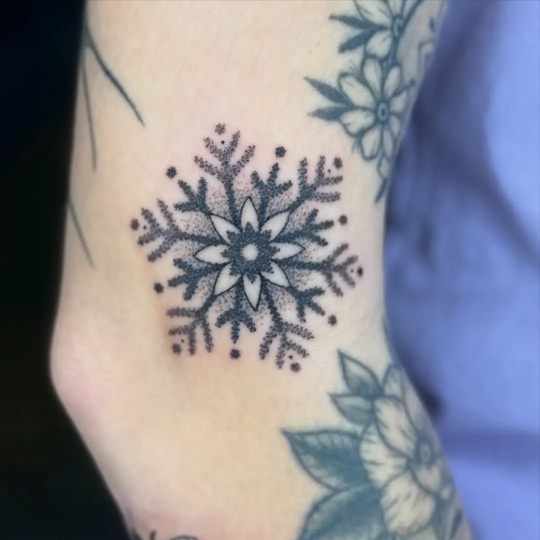 Delicate snowflake tattoo with floral touches