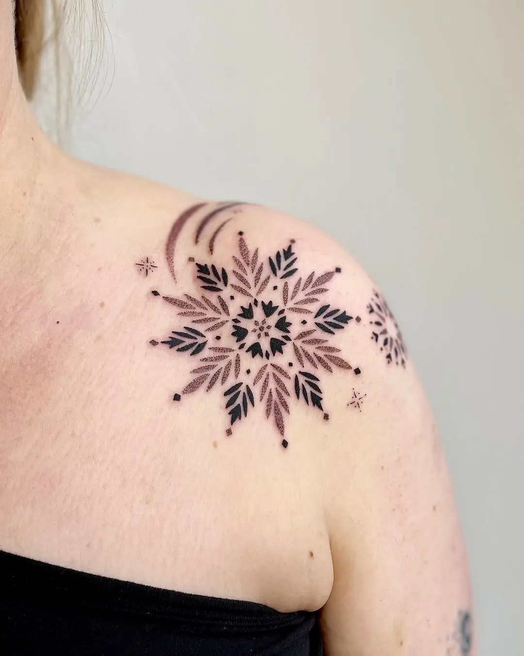 Charming snowflake tattoo on the shoulder.