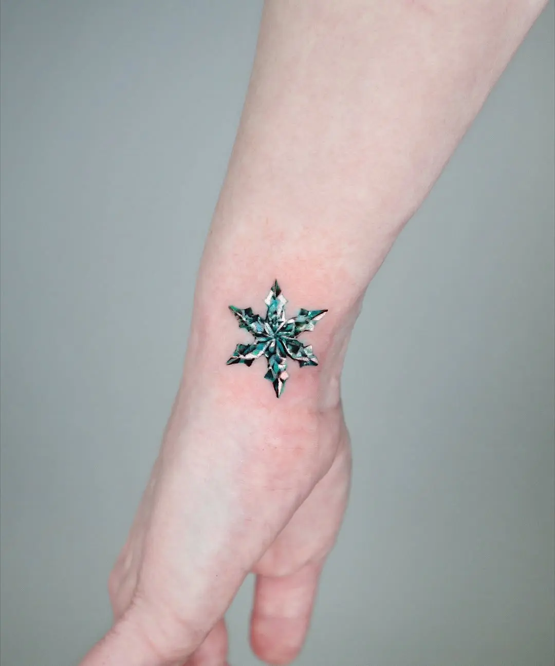 Stunning geometric snowflake tattoo design