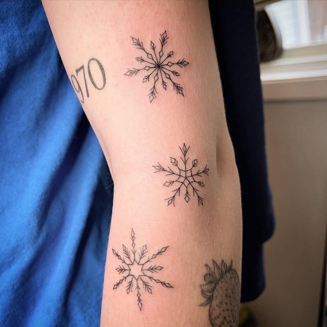 Elegant black ink snowflake tattoo arrangement